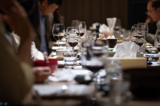 Zdjęcie szklanki wina na stole w pięknej restauracji w nocy z towarzystwem