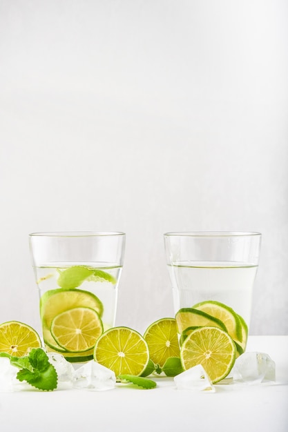 Zdjęcie szklanki z wodą, plasterkami limonki, miętą i kostkami lodu
