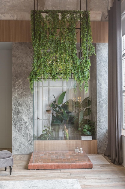 Szklany oddzielny prysznic w stylu dżungli w zieleni w ogromnym nowoczesnym przestronnym mieszkaniu z wysokimi sufitami w stylu loft drewnianymi wykończeniami i szarymi ścianami