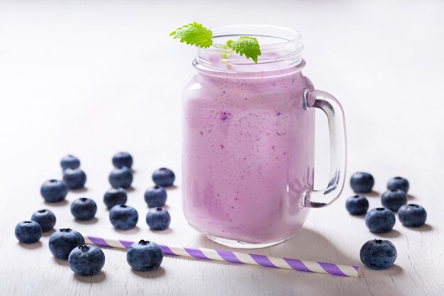 Szklany słoik smoothie jagodowego ze świeżymi jagodami