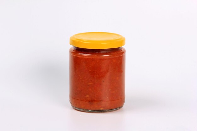 szklany słoik z gotowanym czerwonym sosem pomidorowym na białym tle