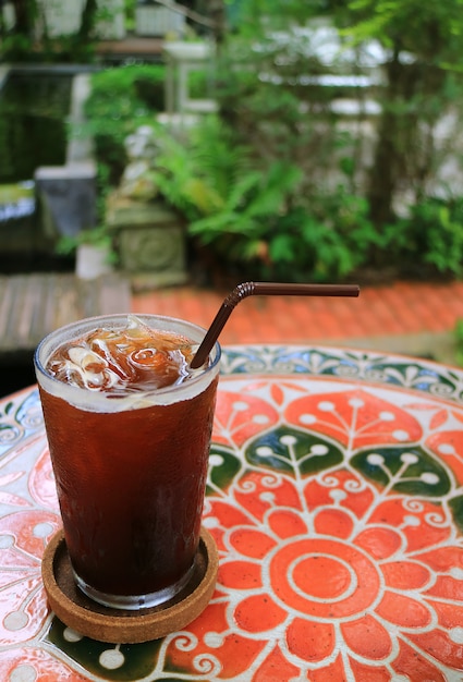 Szkło Lukrowa kawa na stole w lato ogródzie, Zamazany tło