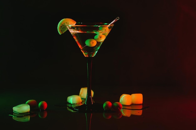 Szkło martini i oliwki na czarnym tle z neonowymi światłami