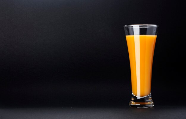 Szkło odizolowywający na czerni z kopii przestrzenią dla teksta sok pomarańczowy, świeży cytrusa koktajl