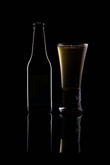 Szkło Pilsner i butelka na czarnym tle na odblaskowej podstawie
