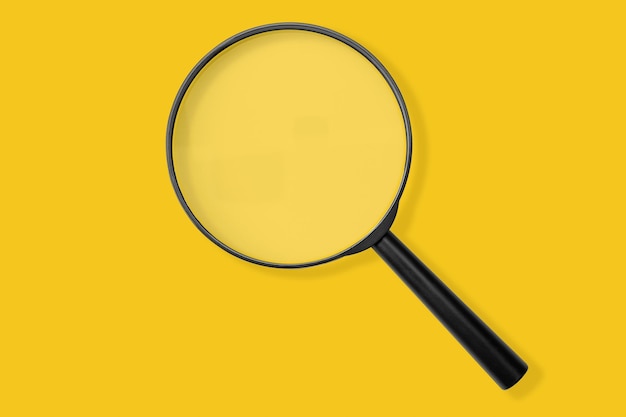 Szkło powiększające czarny kolor na żółtym tle Zbadaj wyszukiwanie sprzedaży lub badanie czegoś z góry