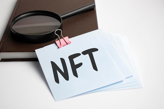 Szkło powiększające ze znakiem NFT na kartce papieru
