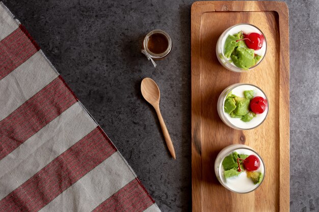 Szkło wiśnia i avocado pokrajać w jogurcie na drewnianym tle