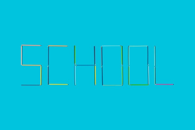 Zdjęcie szkoła programu word napisana kredkami na niebieskim tle minimalna koncepcja