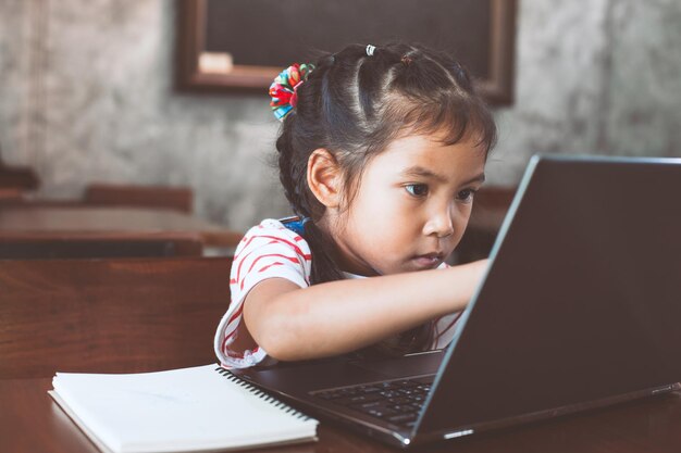 Zdjęcie szkolanka używająca laptopa z ekranem dotykowym w klasie