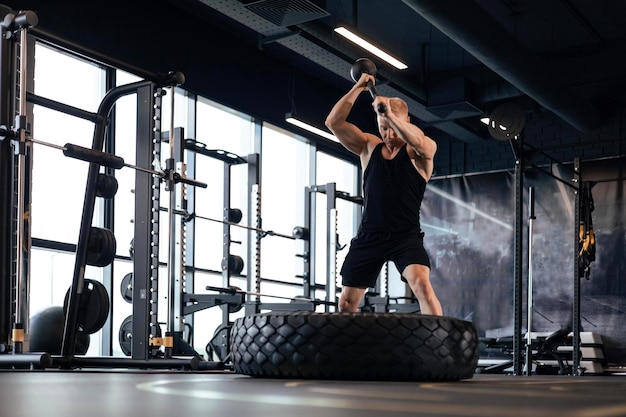 Szkolenie sportowe na wytrzymałość silny człowiek uderzający młot Koncepcja ćwiczeń crossfit