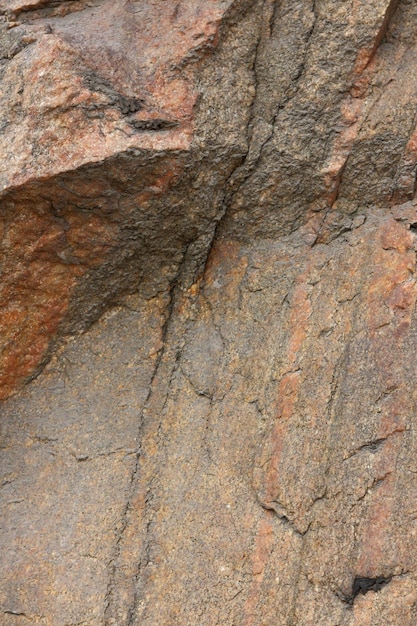 Szorstka brązowa kamienna ściana Naturalna tekstura skały Widok zbliżenie teksturowanej wyblakłej powierzchni