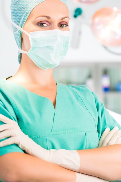 Szpital - młoda lekarka lub chirurg na sterylnej sali operacyjnej, teatrze lub pomieszczeniu czystym kliniki