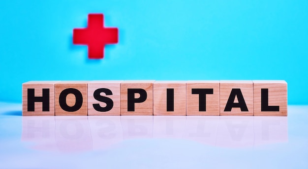 Zdjęcie szpital napis na drewnianych kostkach na niebiesko, na czerwonym krzyżu.