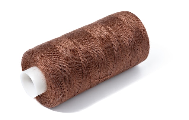 Szpula brązowej bawełnianej nici do robótek ręcznych i szycia na białym, izolowanym tle