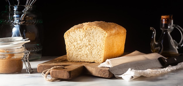 Sztandar świeżego domowego chleba tostowego na ciemnym tle stołu w kuchni