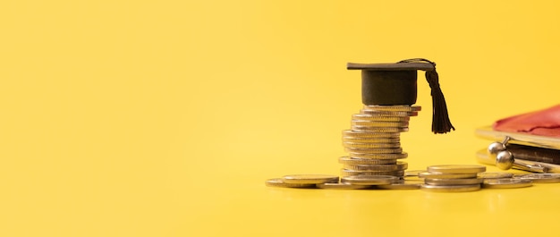 Sztandar z czapką z podziałką z monetami na żółtym tle Oszczędności na koncepcję edukacji