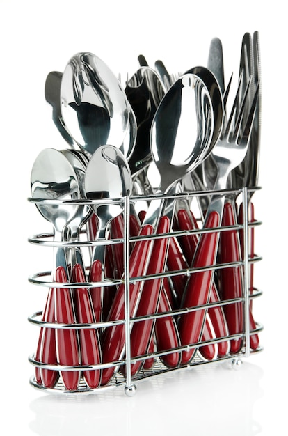 Sztućce kuchenne, noże, widelce i łyżki w metalowym stojaku na białym tle