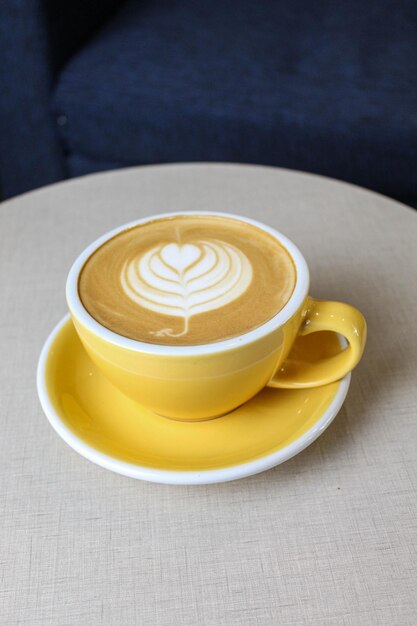Zdjęcie sztuka kawy w gorącej estetycznej żółtej filiżance kawy