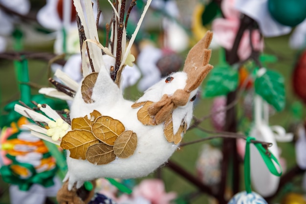 Sztuka ludowa i festiwal pisanek. Ferie wielkanocne. Wielokolorowe pisanki wiszące na sztucznych drzewach