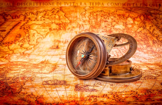 Sztuka martwa. Vintage kompas leży na starożytnej mapie świata w 1565 roku.