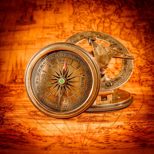 Zdjęcie sztuka martwa. vintage kompas leży na starożytnej mapie świata w 1565 roku.