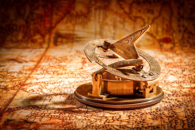 Sztuka martwa. Vintage kompas leży na starożytnej mapie świata w 1565 roku.