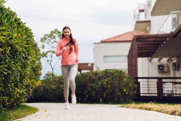 Szybka aktywna dziewczyna w sportowym stroju biega wcześnie rano, chce schudnąć