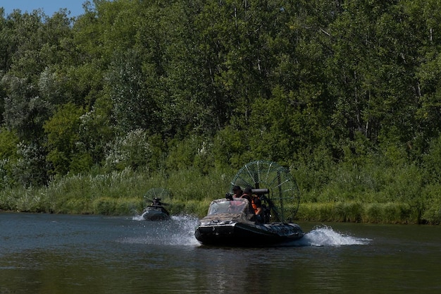 Szybka jazda łodzią powietrzną po rzece w letni dzień z rozpryskami i falami