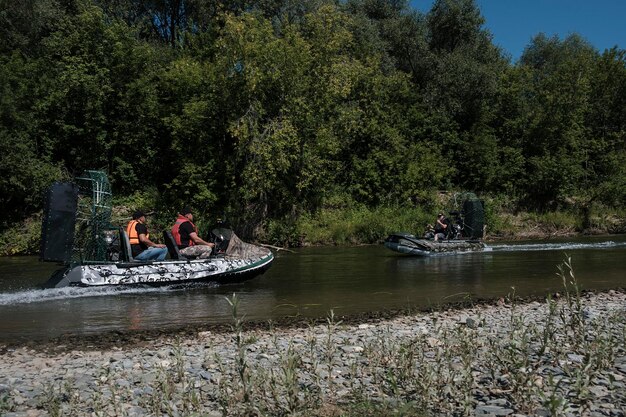 Szybka jazda łodzią powietrzną po rzece w letni dzień z rozpryskami i falami