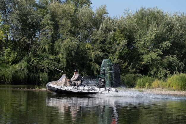 Szybka jazda łodzią powietrzną po rzece w letni dzień z rozpryskami i falami