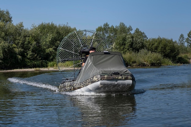 Szybka jazda łodzią powietrzną po rzece w letni dzień z rozpryskami i falami