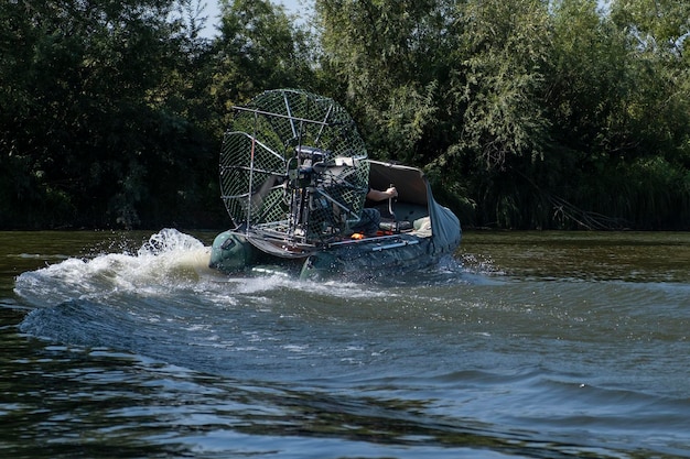 Szybka jazda łodzią powietrzną po rzece w letni dzień z rozpryskami i falami