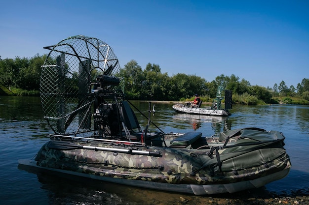 Szybka jazda łodzią powietrzną po rzece w letni dzień z rozpryskami i falami