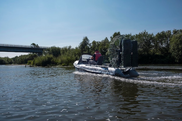 Szybka jazda łodzią powietrzną po rzece w letni dzień z rozpryskami i falami