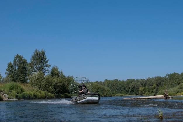 Szybka jazda łodzią powietrzną po rzece w letni dzień z rozpryskami i falami