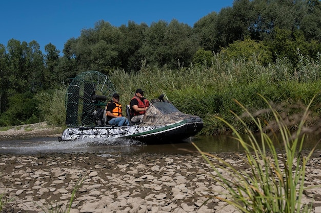 Szybka jazda łodzią powietrzną po rzece w letni dzień z rozpryskami i falami