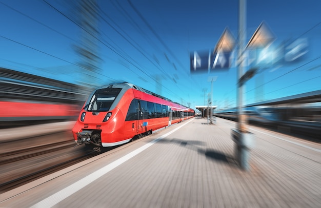 Szybki czerwony pociąg na stacji kolejowej
