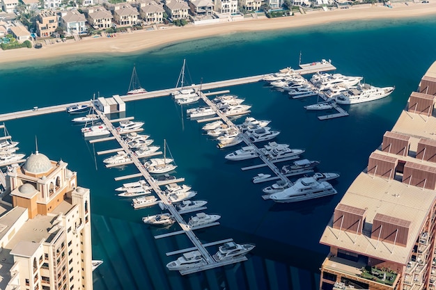 Szybkie łodzie i luksusowe jachty są zaparkowane w porcie na molo w pobliżu plaży Widok z góry