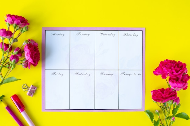 Zdjęcie szybowiec z notatkami i listą rzeczy do zrobienia na żółtym tle z różowymi papeteriami i kwiatami. pomysł na biznes. widok z góry
