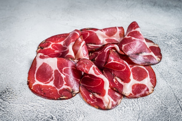 Szynka Coppa Cured Na Stole W Kuchni. Białe Tło. Widok Z Góry.