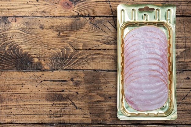 Zdjęcie szynka wieprzowa na cienkie plasterki w opakowaniu próżniowym na stole mięso na plasterkach w pakowaniu do długotrwałego przechowywania