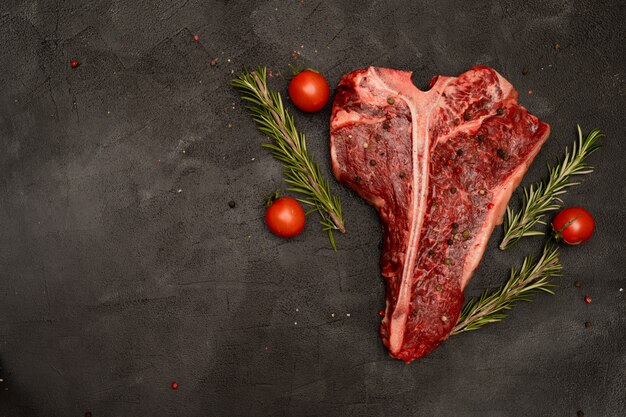 T-bone Lub Porterhouse Z Pomidorami I Rozmarynem Na Czarnym Tle.