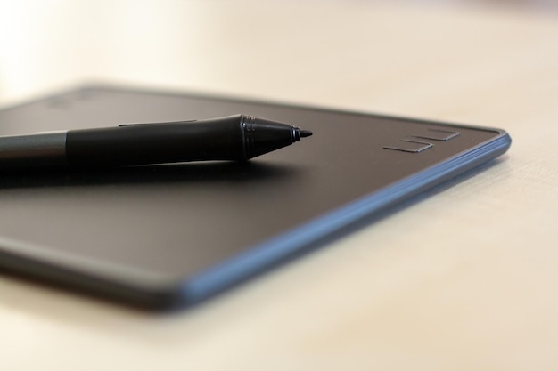 Tablet graficzny z piórem na stole z selektywnym naciskiem na końcówkę rysika
