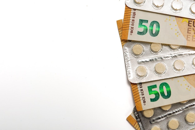 Tabletki w blistrze i rachunki za pięćdziesiąt euro na białym drogiej koncepcji opieki zdrowotnej