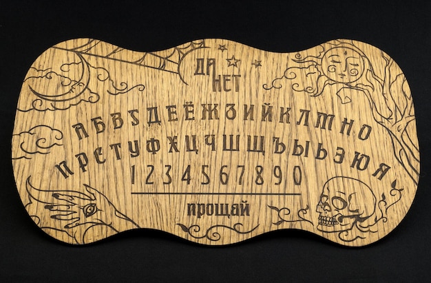 Zdjęcie tablica ouija żółta na czarnym tle