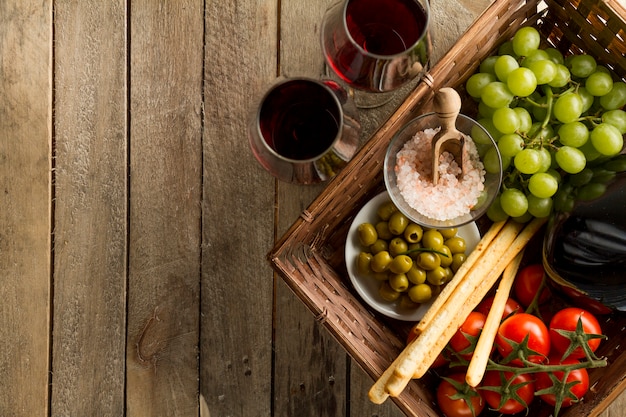 Tablice z kieliszki do wina i kosz pełen zdrowych produktów