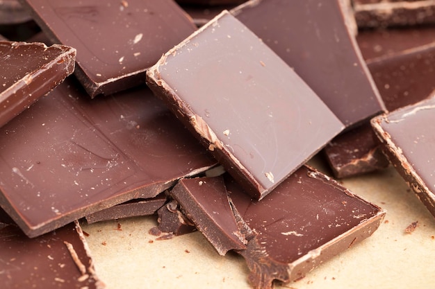 tabliczka czekolady połamana na więcej kawałków, duża ilość kawałków czekolady z okruchami i kawałkami
