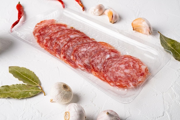 Taca pakowana w plasterki suszonego na powietrzu zestawu mięsa wieprzowego, na białym tle kamiennego stołu