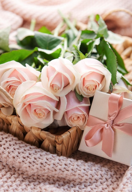 Taca z bukietem pięknych różowych róż i pudełkiem na łóżku